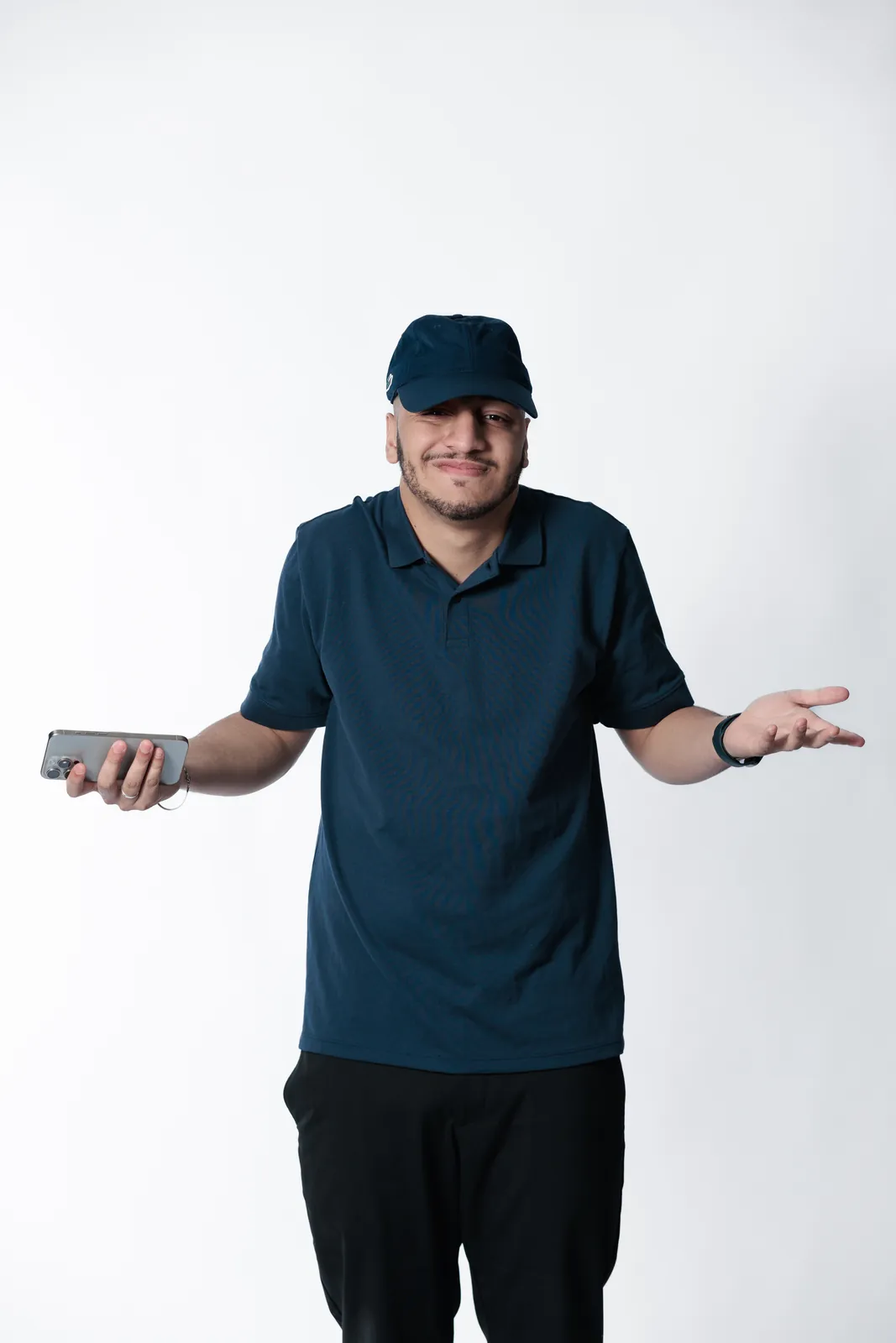 Thiago Máximo de boné segurando o celular