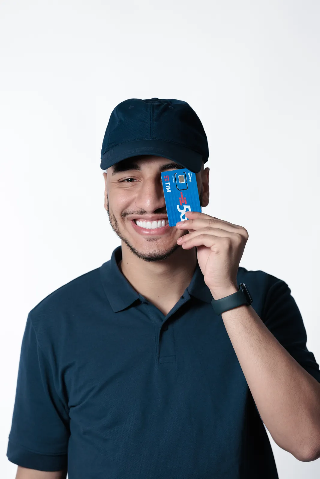 Thiago Máximo sorrindo com um chip de celular na mão